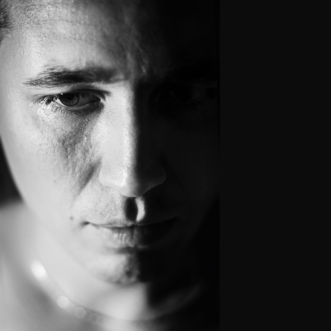 Black and white close up of a man's face who is depressed