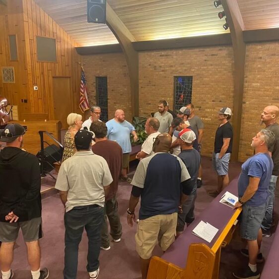 People standing around in a circle inside of a church