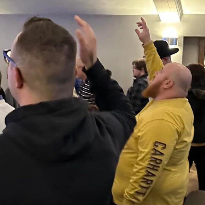 Men standing and raising their hands in worship